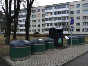Colour coded recycling bins line a quiet residential street on collection day.